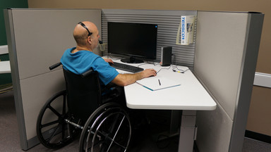 Mann im Rollstuhl am Arbeitsplatz