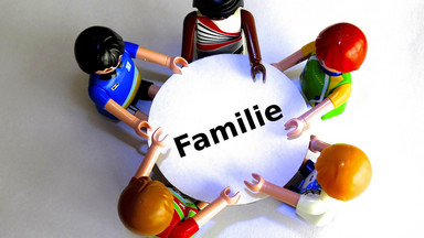 Figuren um runden Tisch, Schriftzug "family"