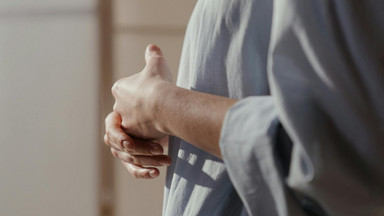 Eine Frau hält ihre Hände nachdenklich oder schützend vor ihren Körper