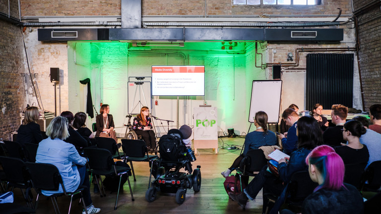 Verschiedene Menschen bei einem Vortrag