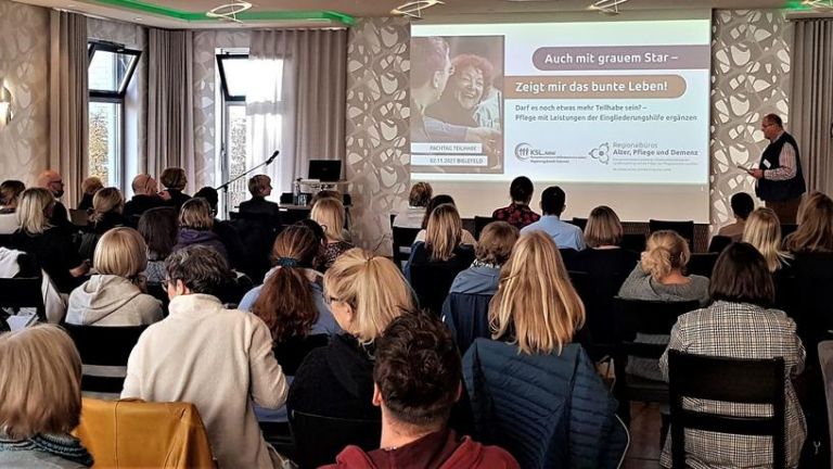 Bild von hinten in den Veranstaltungsraum mit Teilnehmer:innen