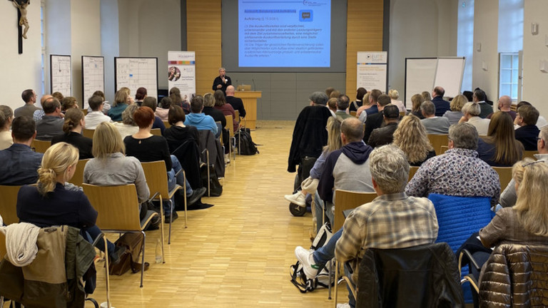 Ansicht des Veranstaltungsraums mit Teilnehmer*innen von hinten
